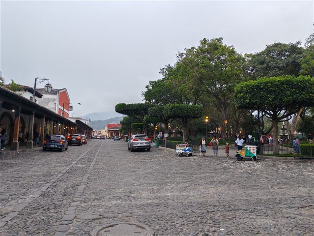 A cobbled street in Antigua Guatemala with the volcano behind